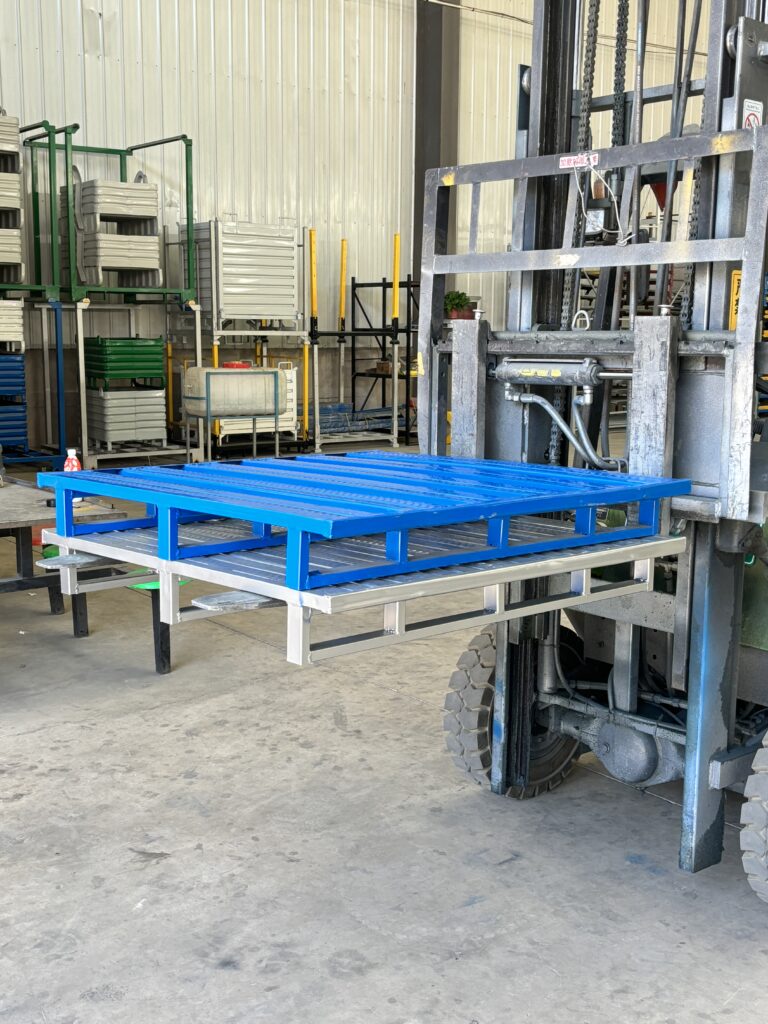Forklift handling heavy duty right angle steel pallets in factory